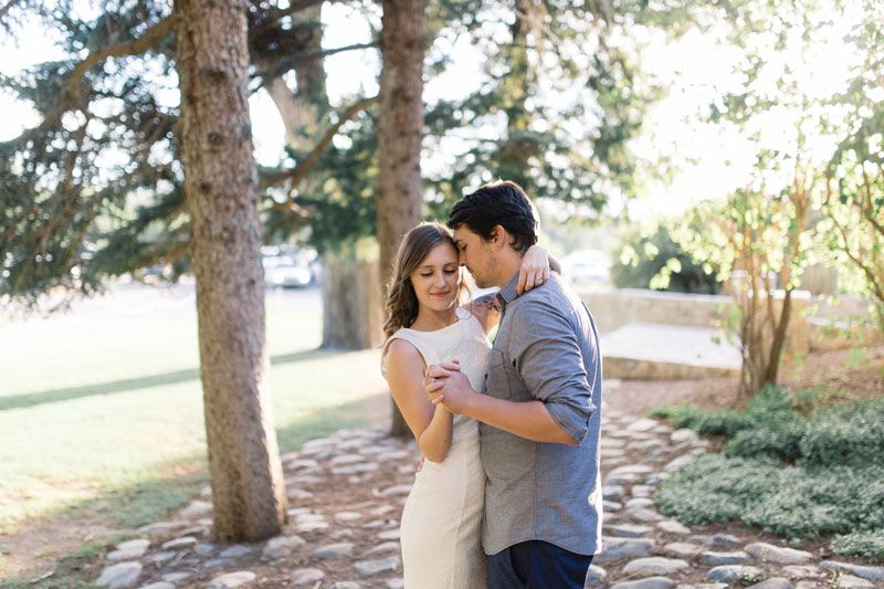 Husband and wife dancing in an outdoor location with trees surrounding them