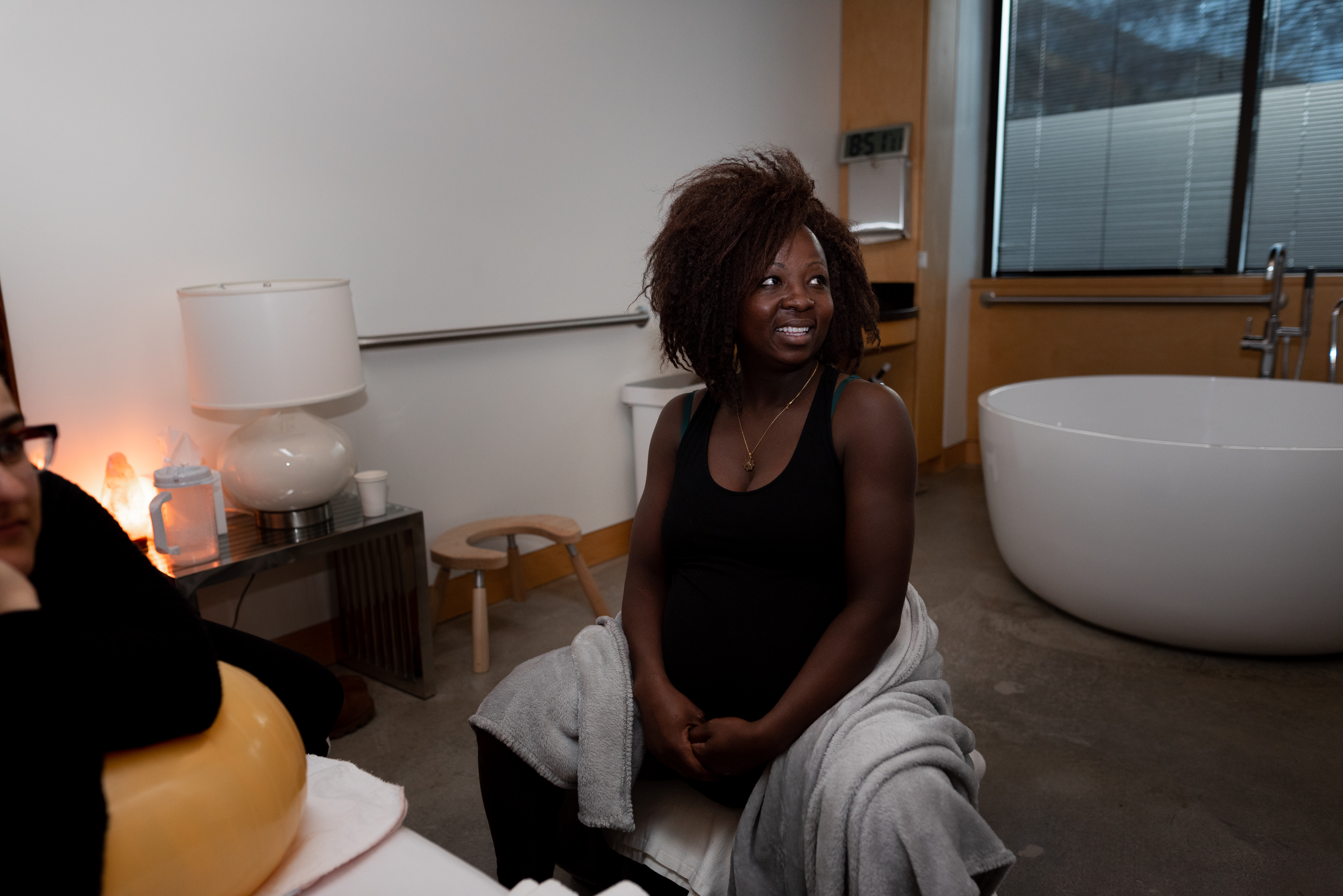Laboring mom sits on birth ball during a birth photography session