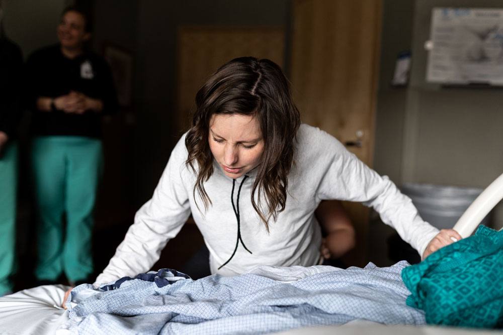 Woman focuses on contraction while getting ready for the birth of her son