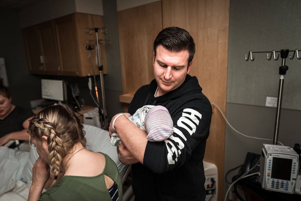 Dad holds his baby and looks at him in awe