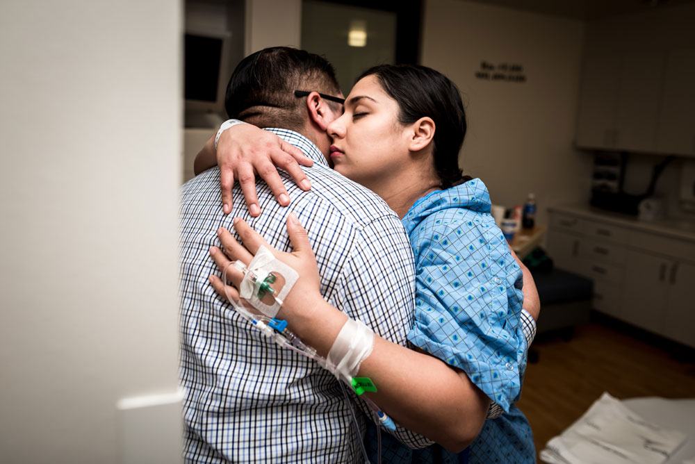 Mom holds on to her husband during a contraction during a hospital birth