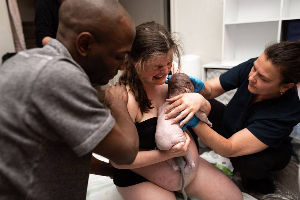 Mom holds baby A while getting another contraction in preperation of the birth of Twin B