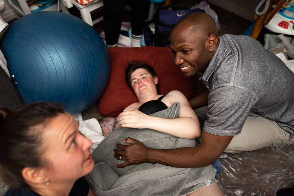 Dad smiles at midwife after the birth of his twin sons at home