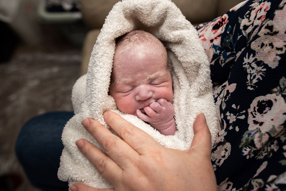 Baby A sucks on his fingers after being born at home