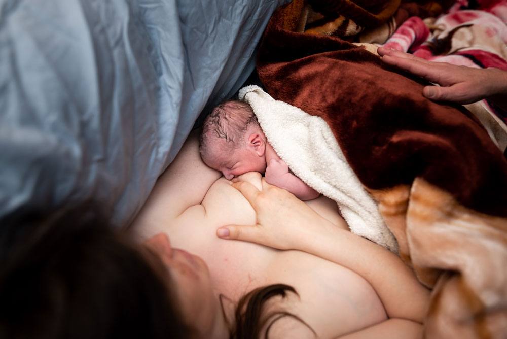 Mother attempts to breastfeed twin A for the first time after home birth