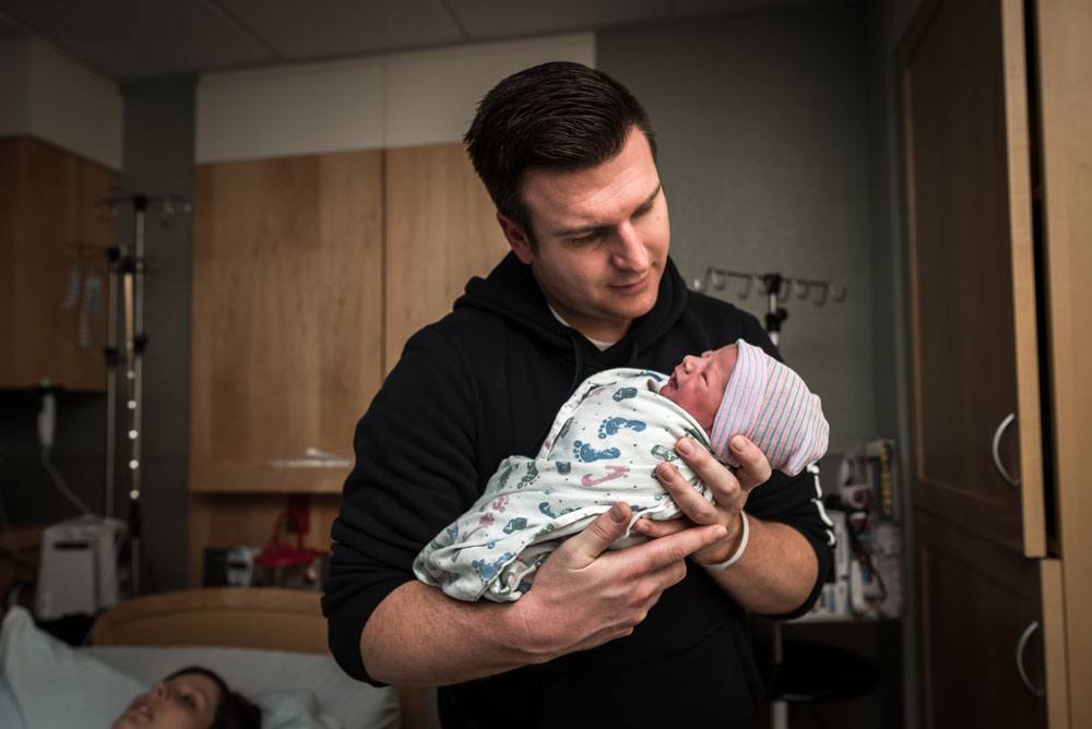 Dad admires his son in hospital after his birth
