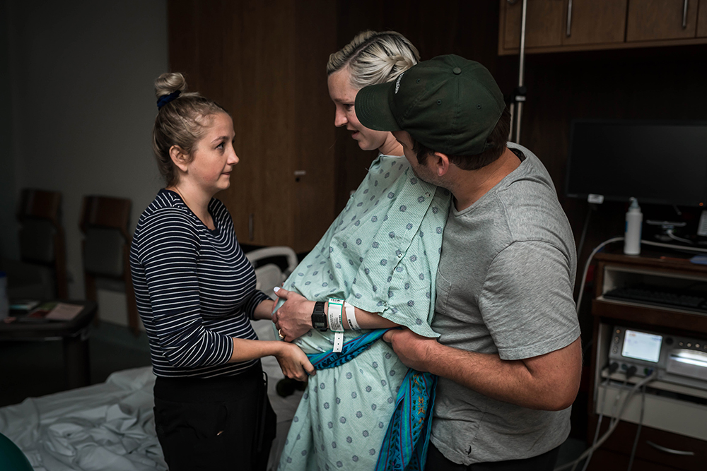 Doula and husband support laboring mom in hospital room during labor