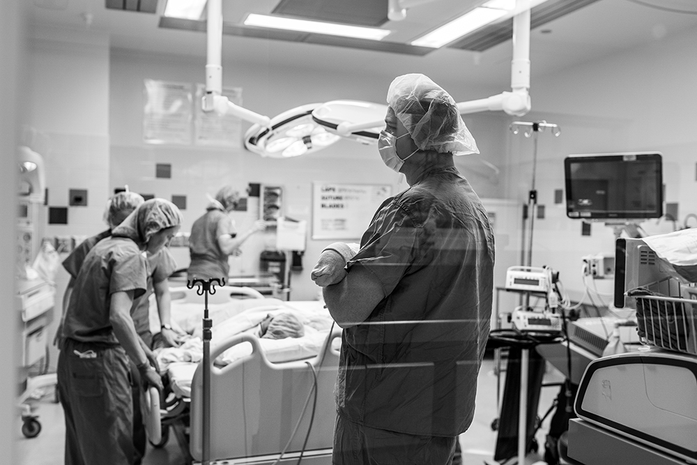 Dad stands in the or while wife is getting ready to be moved into recovery