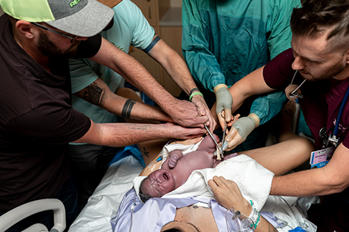 Dads cut the umbilical cord of their newborn baby son