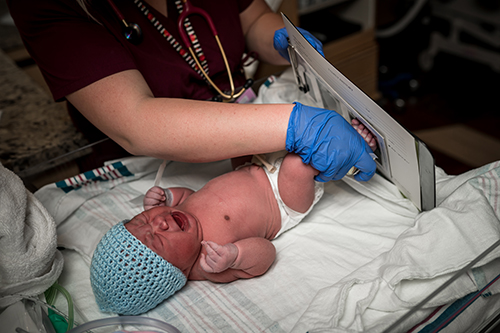 Newborn baby's footprint is documented by nurse in hosptial