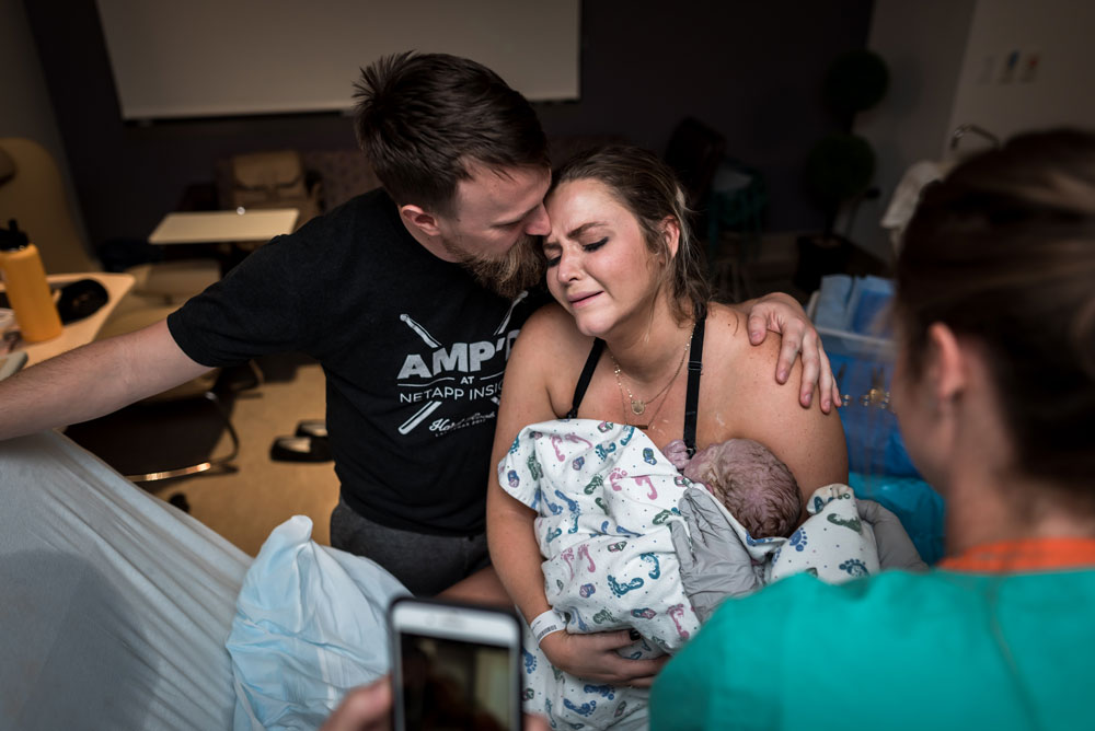 Mom and dad cry and hug after mom gives birth to her newborn son