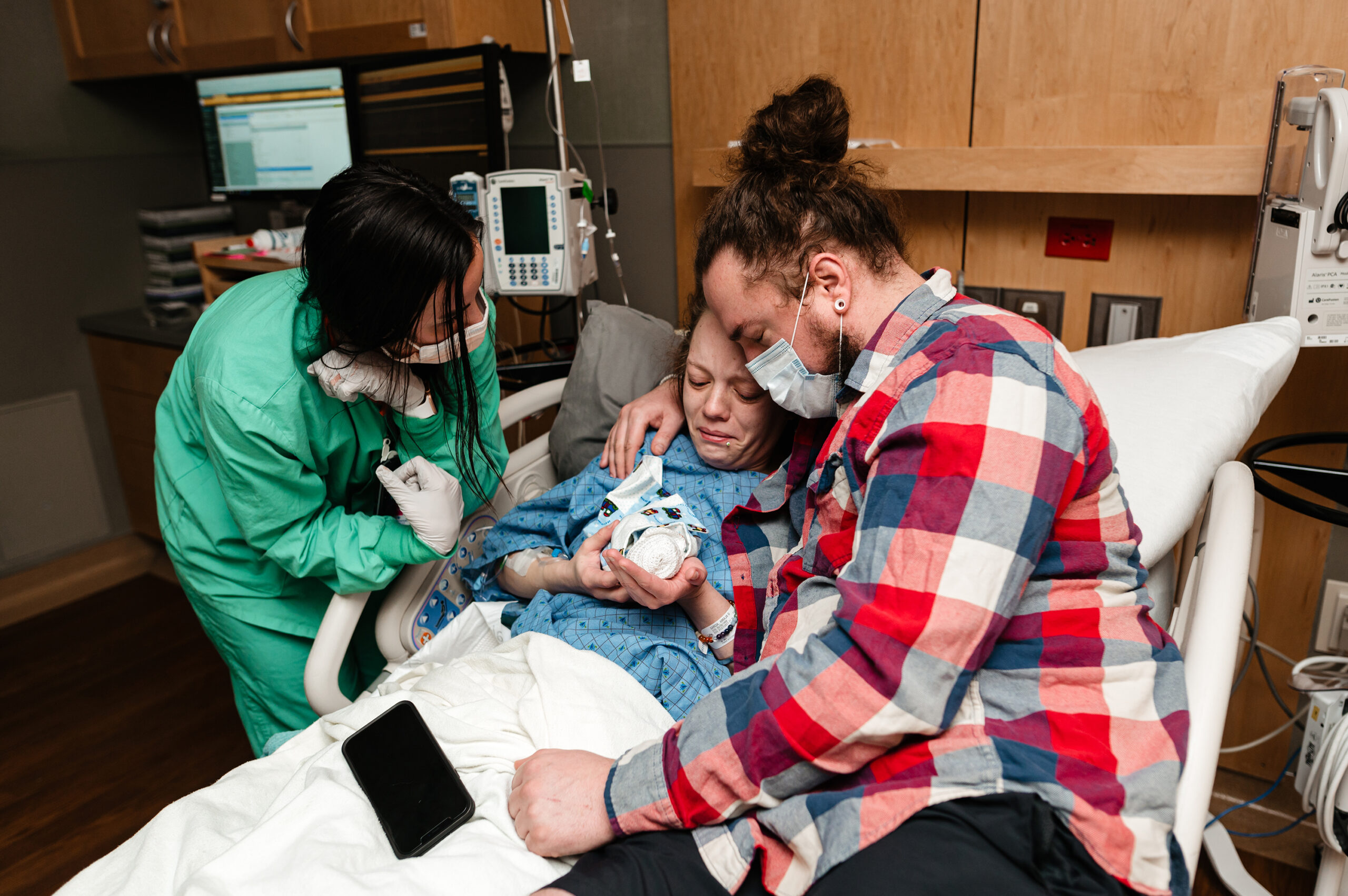 Parents hold their 19 week gestation baby in hospital bed