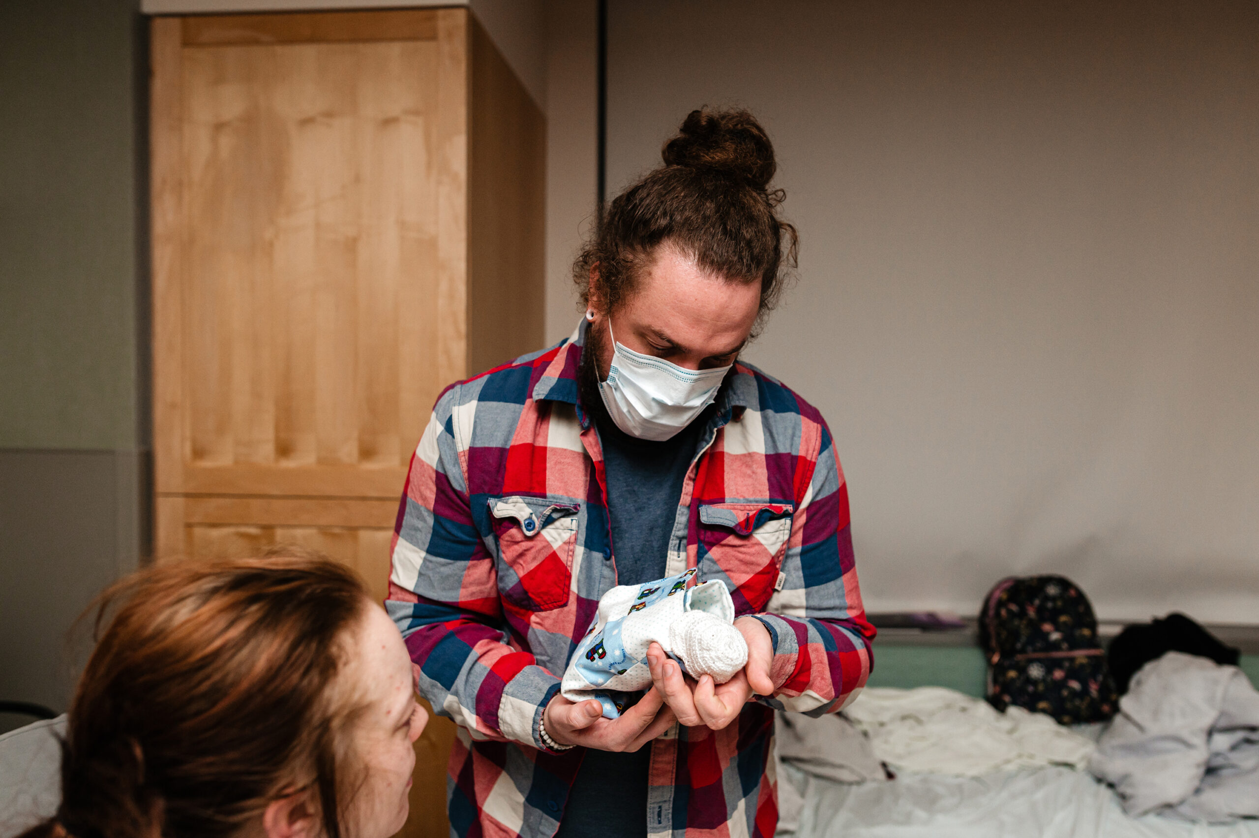 Father holds baby in hospital room