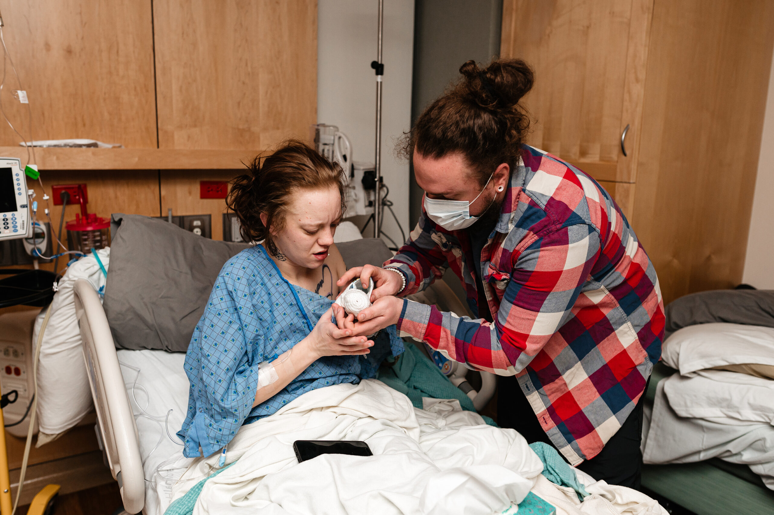 Parents hold their 19 week gestation baby in hospital bed