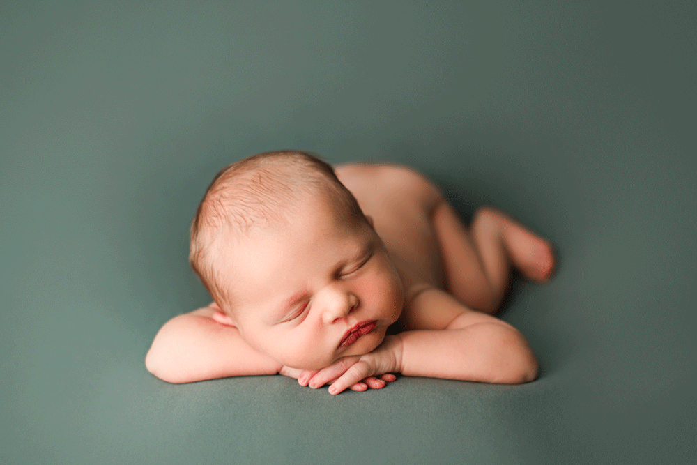 Newborn baby sleeping on hands during newborn photography session